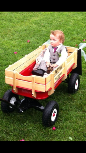 Cam holding the ring box and getting pulled down the aisle by Eric. 